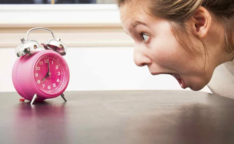 Woman looking at alarm clock